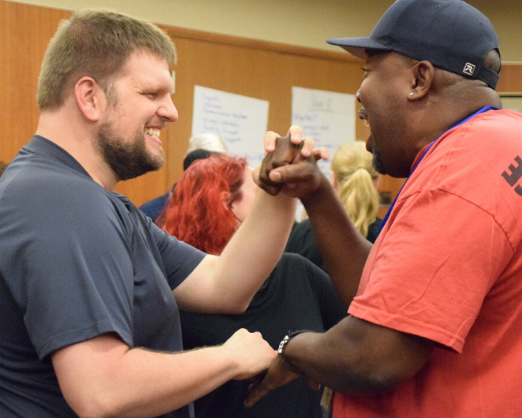 Two men communicate tactile sign.