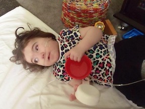 A child plays with a measuring cup.