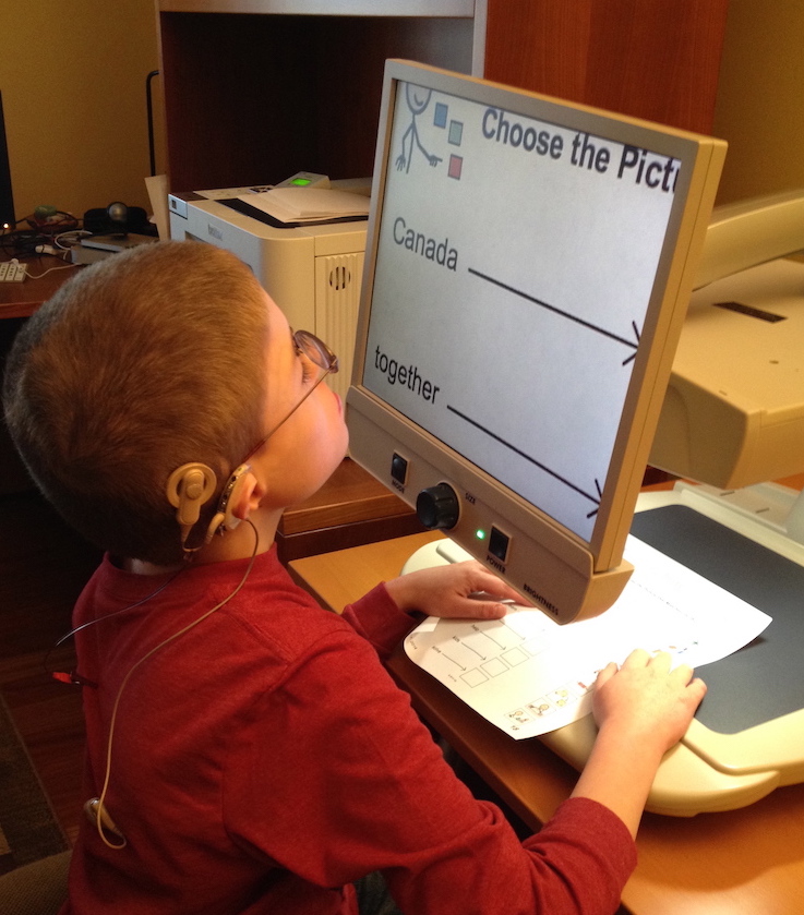 Ethan reading using a magnifier