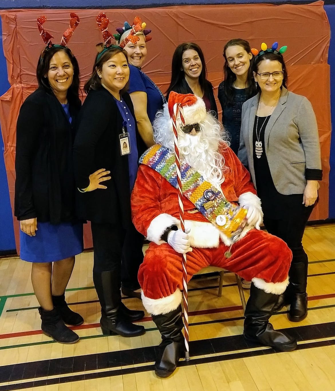 FECs taking a picture with Santa while holding the scarf.