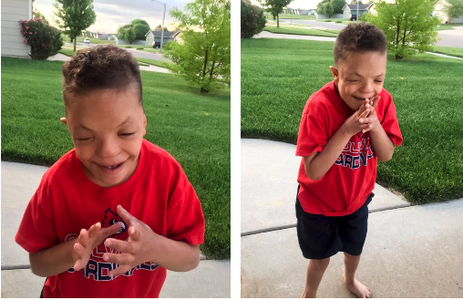 Devin is wearing a red t-shirt. He is standing outside